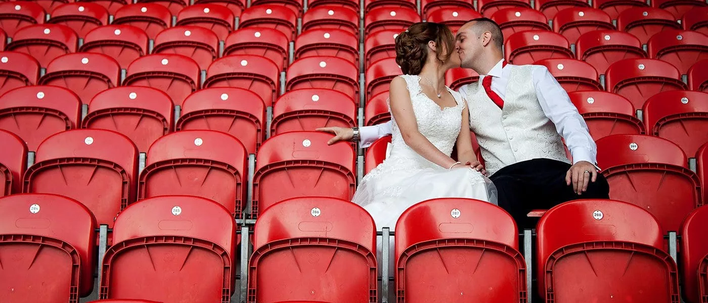 Newly married couple kissing whilst sat in the BrewDog Stadium seats