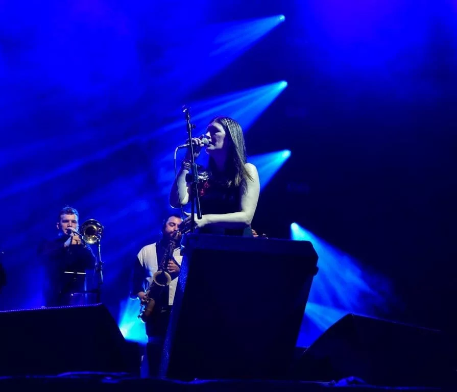 woman singing with blue backdrop
