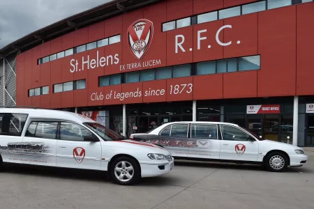 white funeral cars outside stadium