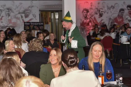 man dressed as elf speaking into microphone